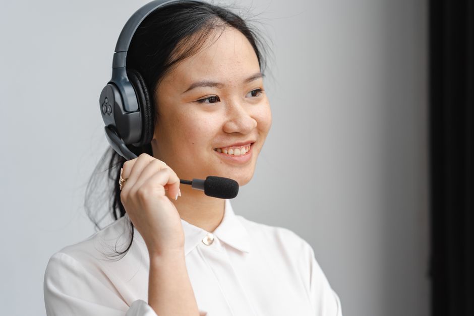 Smiling call center employee using a headset for effective customer communication.